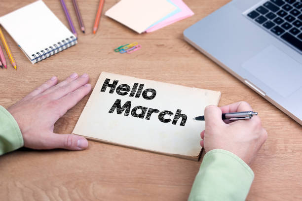istock Hand writing Hello March. Office desk with a laptop and stationery 646464018
