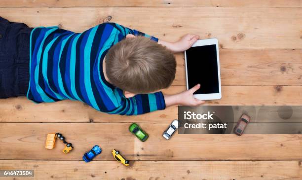 Kid On Floor With Tablet Pc Stock Photo - Download Image Now - Child, Digital Tablet, Lying Down