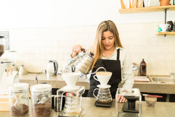 istock Pretty female barista brewing coffee 646484512
