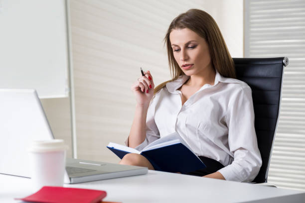istock Serious businesswoman with notebook and pen 646487496