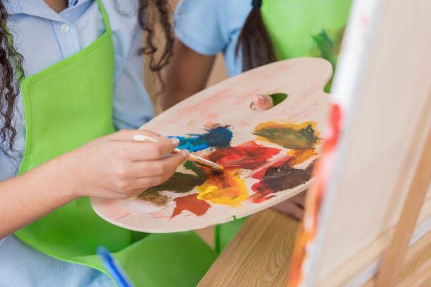 istock Female art student uses palette in art class 646498392