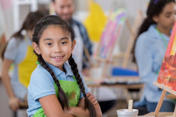 istock Confident young girl participates in art class 646498396