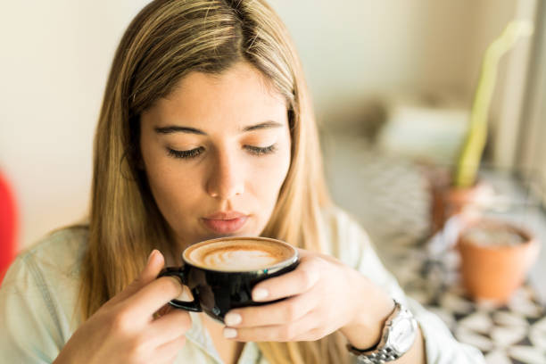 istock Woman drinking cappuccino in a cafe 646504172