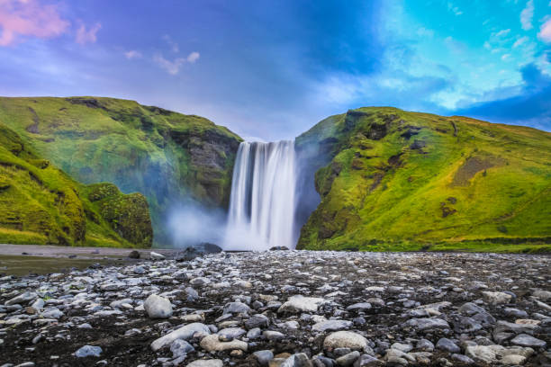 Classic view of famous Skogafoss waterfall in twilight, Iceland Classic long exposure view of famous Skogafoss waterfall in beautiful twilight during blue hour at dusk in summer, Skogar, south of Iceland golden circle route photos stock pictures, royalty-free photos & images