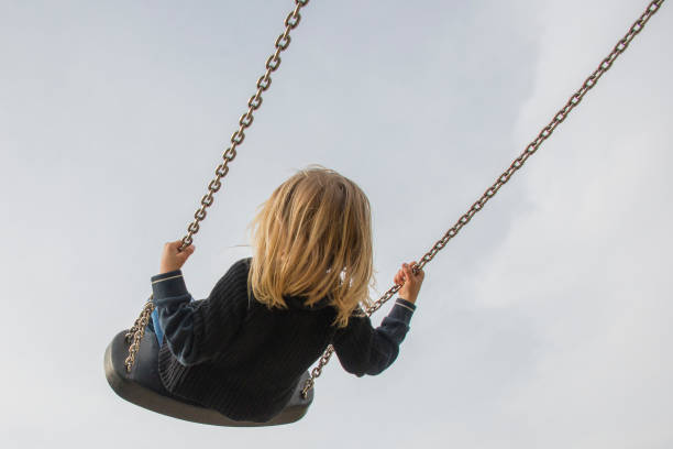 istock Little child blond girl having fun on a swing 646514864