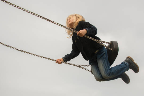 istock Little child blond girl having fun on a swing 646514920