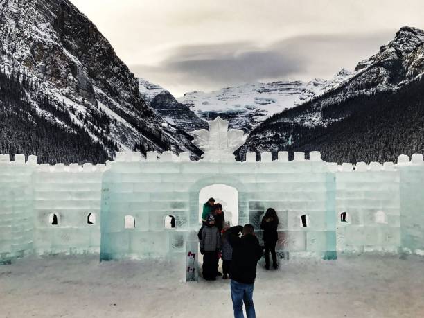 레이크 루이스에서 밴프 국립 공원, 앨버타, 캐나다에서 연례 얼음 조각 축제 기간 동안 얼음 성 앞에 서 있는 사람들 - ice sculpture built structure snow ice 뉴스 사진 이미지