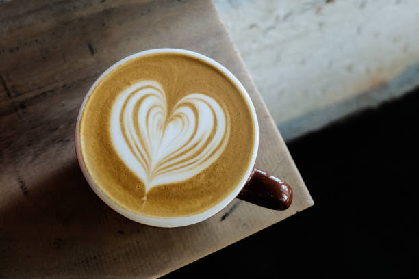 filiżanka do kawy z latte sztuki na stole z drewna - froth art zdjęcia i obrazy z banku zdjęć