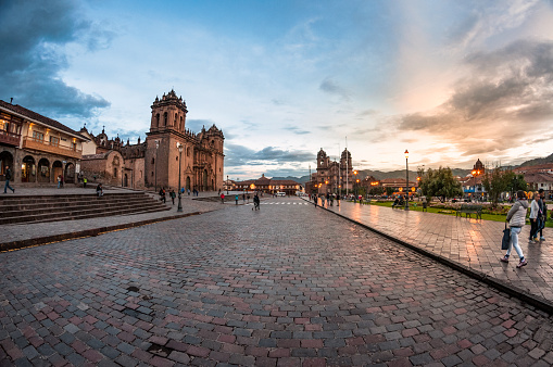Cuscu, Peru – April 9, 2016: People walking around the Plaza Mayor Del Cusco in Cuzco city centre at sunset.