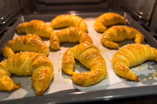 Croissants tray pulling out of oven