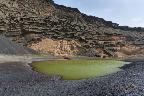 ve en un cráter volcánico con su lago verde cerca de el golfo, isla de lanzarote, españa - lanzarote bay canary islands crater fotografías e imágenes de stock