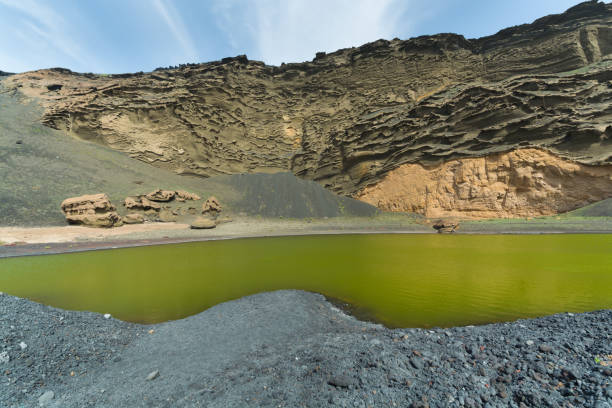 ve en un cráter volcánico con su lago verde cerca de el golfo, isla de lanzarote, españa - lanzarote bay canary islands crater fotografías e imágenes de stock