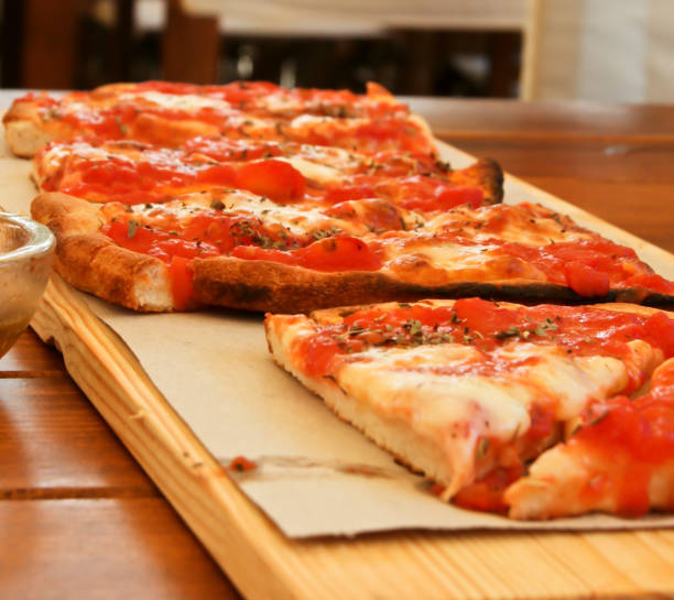 Some slices of pizza on a wooden plate stock photo