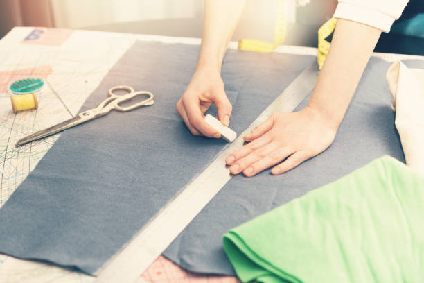 istock tailor occupation - marking fabric with chalk for cutting 646563270