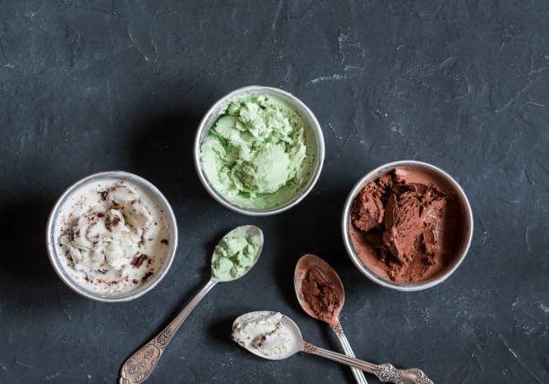 Range of coconut milk ice cream with chocolate, matcha powder, chocolate chips and vanilla. On a dark background, top view. Gluten free vegetarian dessert