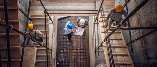Construction workers and architects viewed from above Construction workers and architects at a construction site viewed from above. foreperson photos stock pictures, royalty-free photos & images