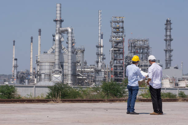 ingegneria meccanica che lavora nella raffineria di petrolio - factory site foto e immagini stock