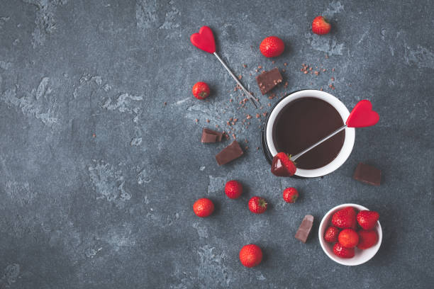 fonduta di cioccolato con fragola fresca su sfondo scuro - heart shape snack dessert symbol foto e immagini stock