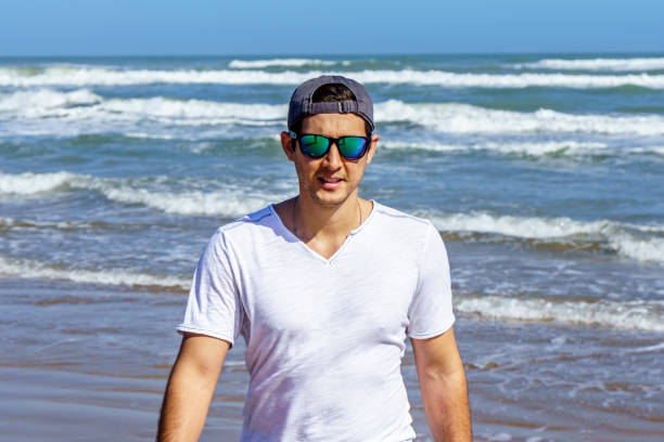 Lifestyle portraits of young Brazilian man running in the sea at the water's edge