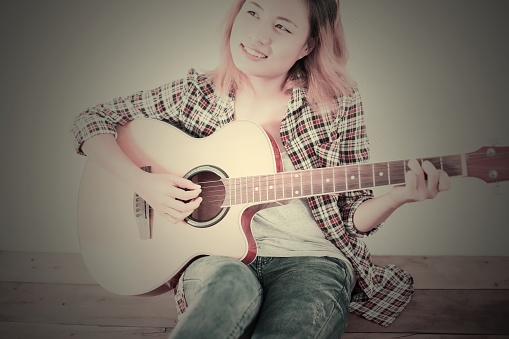Hipster woman style portrait enjoy with guitar look so happy.