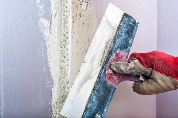 istock Repairing fireplace surface with spackle and trowel by hand 646613638
