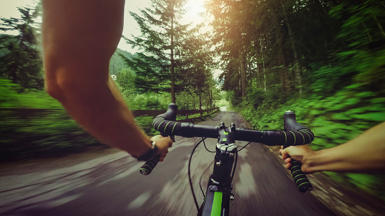 POV riding a road racing bicycle in the forest