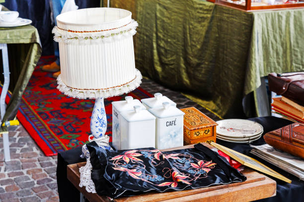 Montreux, Switzerland - May 25, 2013: Lamp among other antiques put on sale at the famous Covered Market. On the wooden table other smaller stuff can be seen