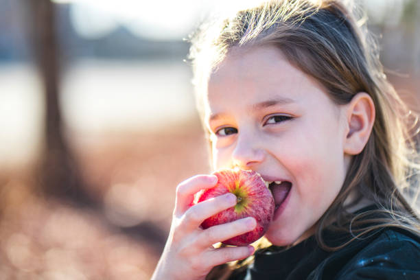 istock Little girl eating an apple 646644400