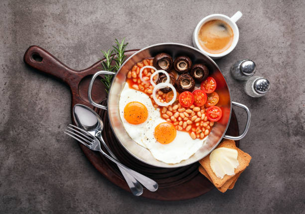 istock Full English Breakfast with fried eggs, beans, toasts, tomatoes , mushrooms and coffee on grey background 646650946