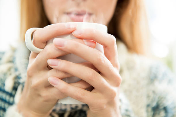 Woman drinking coffee. Woman holding cup of hot coffee in hands. Inhaling aroma, enjoying morning. Brightly lit kitchen in the morning. young hot stock pictures, royalty-free photos & images