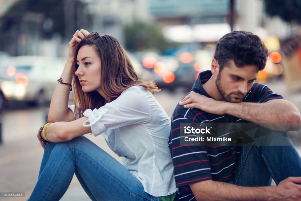 Sad couple leaning on Girl and boy sitting sad and upset leaning on each other Sadness Stock Photo