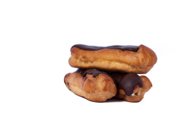 istock Sweet three chocolate eclairs isolated on white. Traditional french cakes cooked from choux dough filled with a cream 646677516