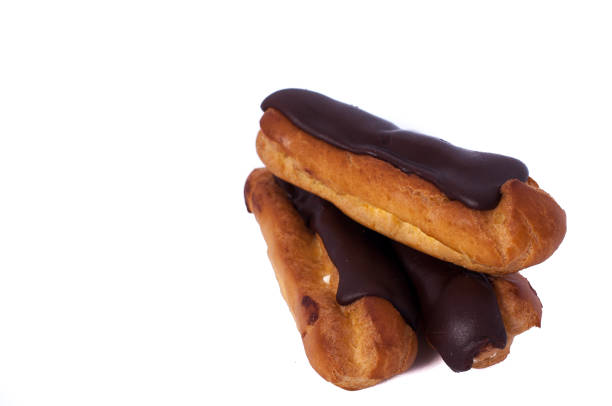 istock Sweet three chocolate eclairs isolated on white. Traditional french cakes cooked from choux dough filled with a cream 646677572
