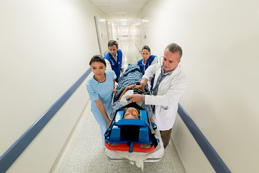Group of doctors attending an emergency at the hospital - healthcare and medicine concepts