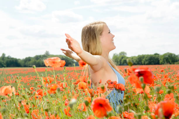 istock woman cheering in poppy field 646686962