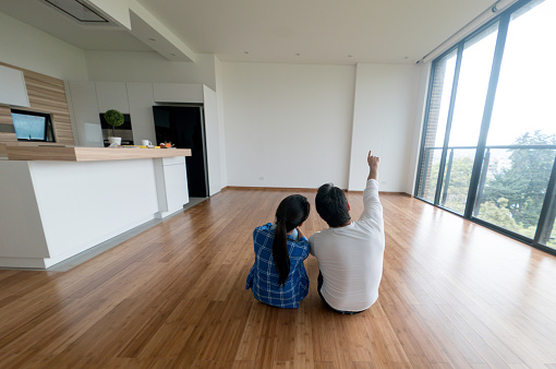Loving couple at their new home sharing ideas about how to decorate it - real estate concepts