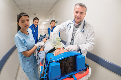 Patient arriving at the Emergency Room and being attended by a group of doctors - healthcare and medicine