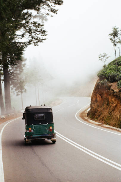 Tuk-tuk taxi on the road in moutnains in Sri Lanka Tuk-tuk taxi on the road in foggy moutnains in Sri Lanka taxi sri lanka stock pictures, royalty-free photos & images