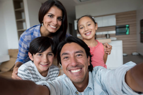 Family taking a selfie while moving home Family taking a selfie while moving home and looking very happy - lifestyle concepts photo messaging stock pictures, royalty-free photos & images