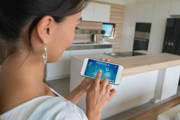istock Woman using smart home app on her cell phone 646688758