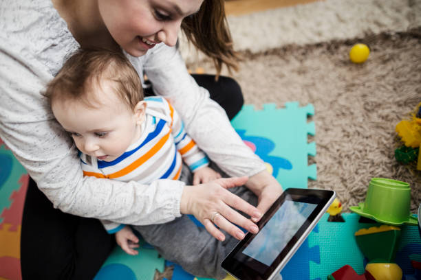 istock Mother and baby playing with digital tablet 646696700