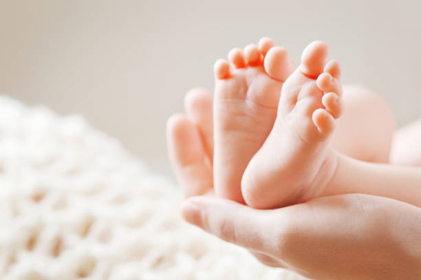pies de bebé en manos de la madre. madre y su hijo. - pies fotografías e imágenes de stock