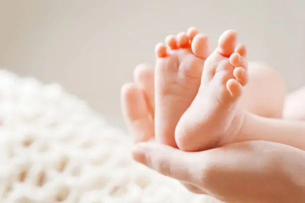 Photo of Baby feet in mother hands. Mom and her Child.