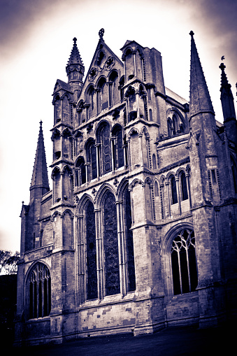 Ely Cathedral in Cambridgeshire taken from the open grass area surrounding it. This is a view of the rear of the building split toned.