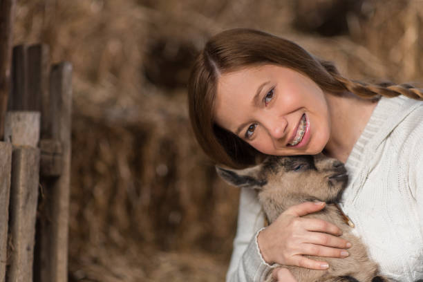 istock Eastern Europe: Lifestyle-Young woman hugging kid goat 646714370