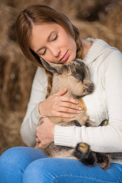 istock Eastern Europe: Lifestyle-Young woman hugging kid goat 646717046