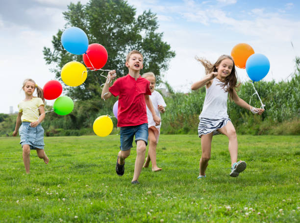 istock Four friendly glad kids running on green lawn 646726676