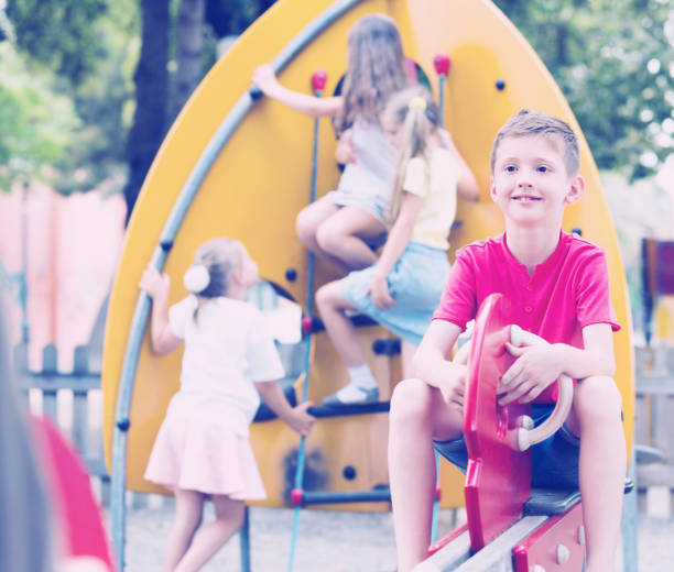 istock Smiling boy  sitting on swing on children's playground 646726682
