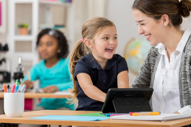 istock Excited kindergarten student uses digital tablet at school 646729854