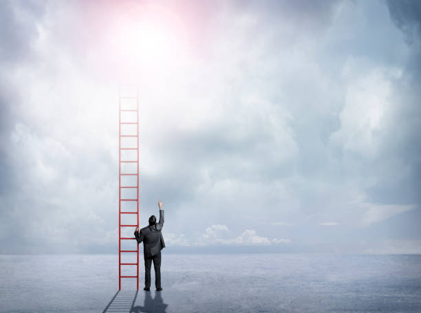 istock Businessman Holding Ladder Looking Up Towards Sky 646740990